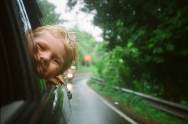 A child leaning out of a car window