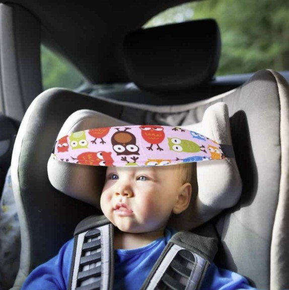 A baby wearing a headband while in a car seat