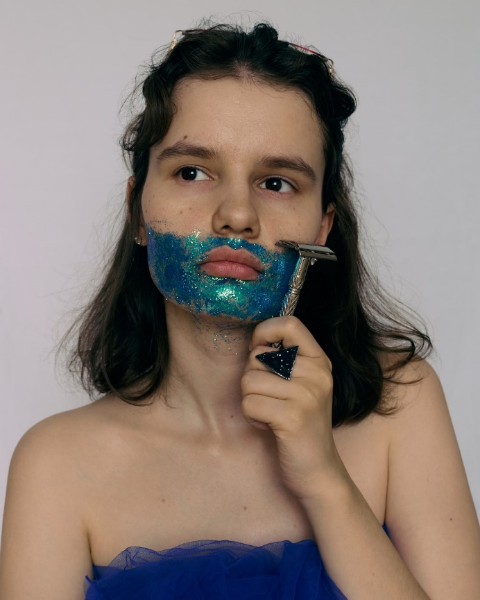 A woman holding a razor to her face