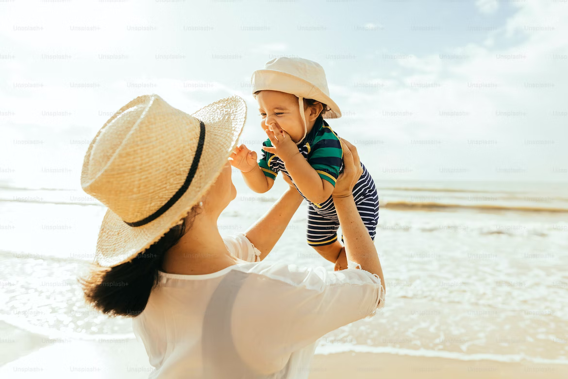 A woman playing with her baby on a beach